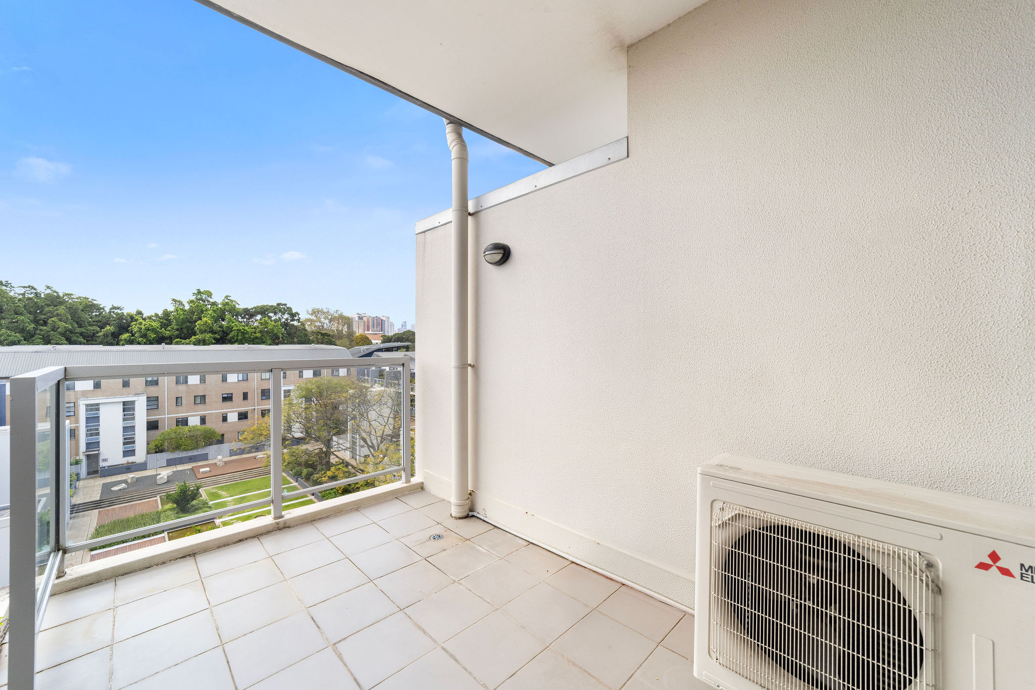 Balcony view of stylish two-level furnished loft in Alexandria, overlooking tranquil communal gardens and urban landscape.
